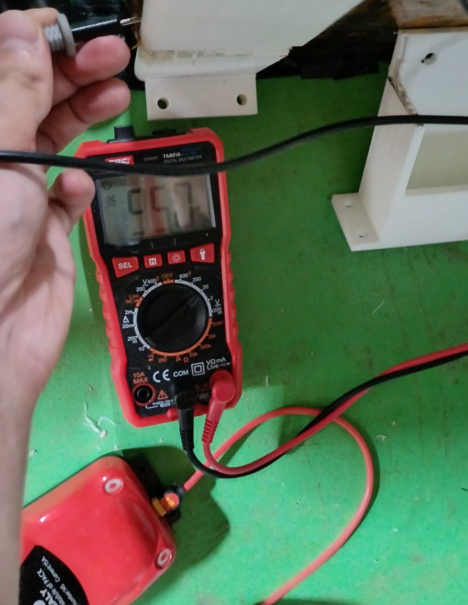 TASI TA801A cheap multimeter for car electrical work measuring battery pack voltage through a DALY BMS on a workbench