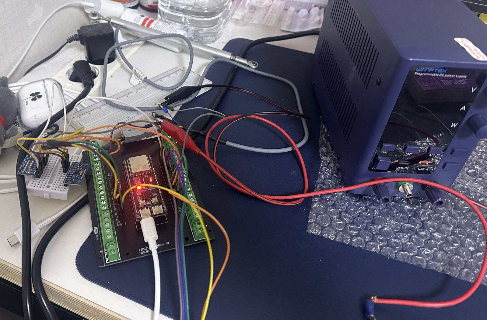 ESP32 datalogger bench setup with ADS1115 on a breadboard, linear potentiometer, and a lab power supply