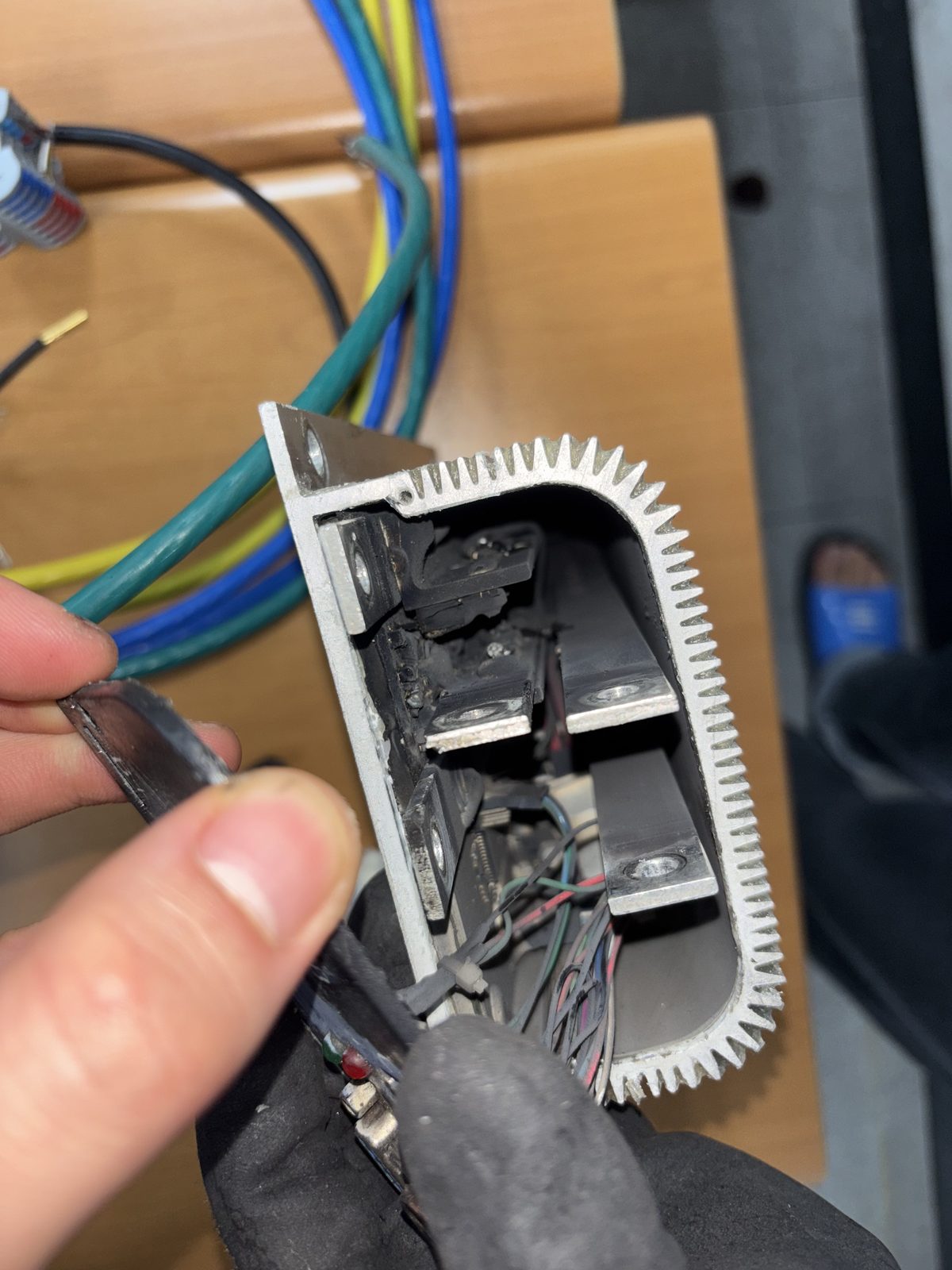 Motor controller cut open showing a carbonised interior after two ring terminals touched and shorted