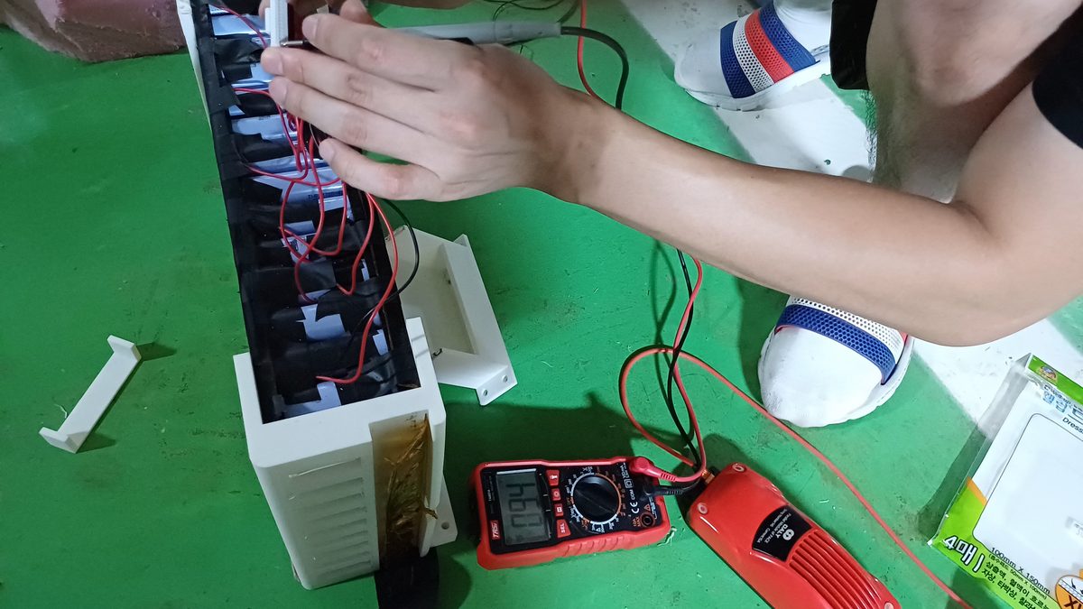 Using a digital multimeter to check voltages on a student race car's battery pack wiring